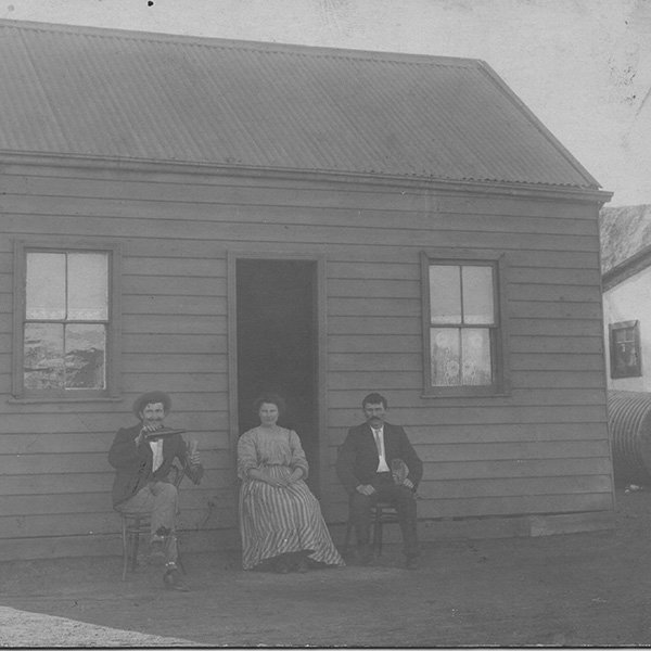 Ivan and Maria Tomich’s home in Boulder, 1912. They are celebrating the recent completion of their home on the Boulder Leases. Slime dumps can be seen in the background. Photo courtesy Alma Smith (before processing).