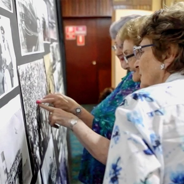 Excited members of the community attending the launch identify family and friends in the photos on display.