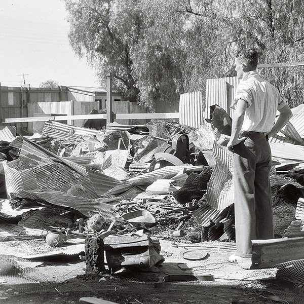 A picture of a man surveying the debris of his house destroyed in the Kalgoorlie riots, January 1934. He