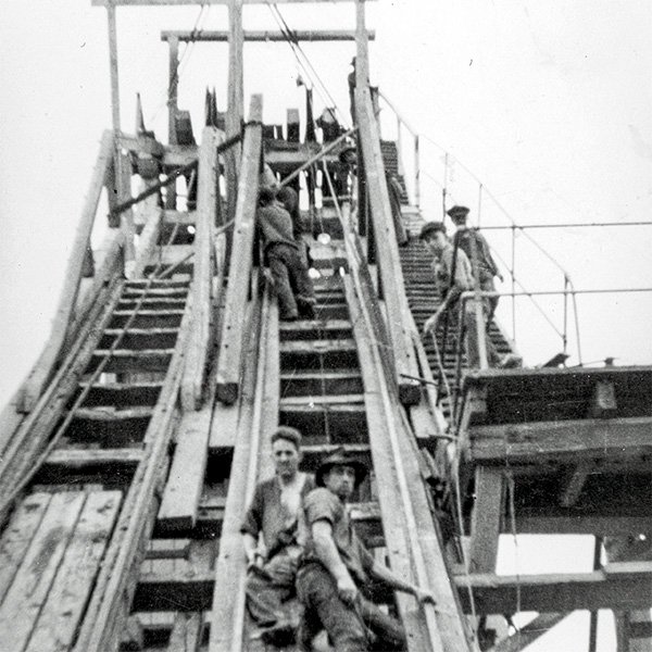 Picture, taken from below, showing a group of workers making repairs to a mine